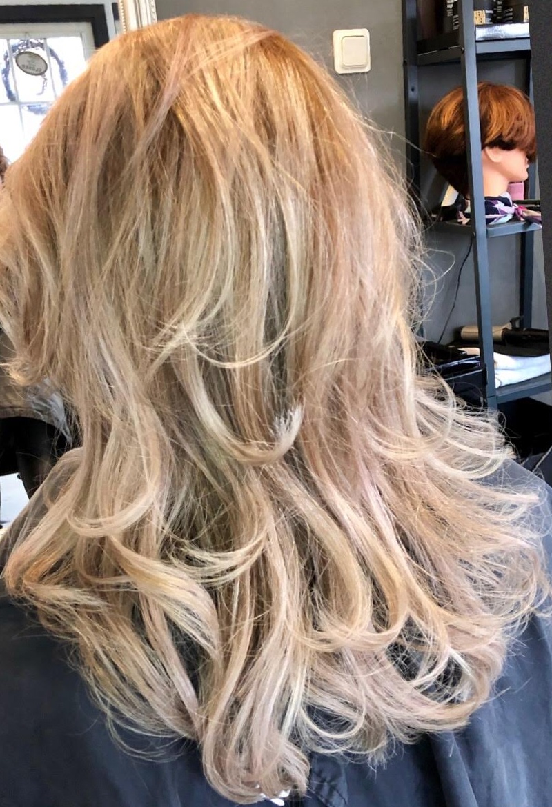 Blond haar met highlights en een gekrulde föhnbehandeling
